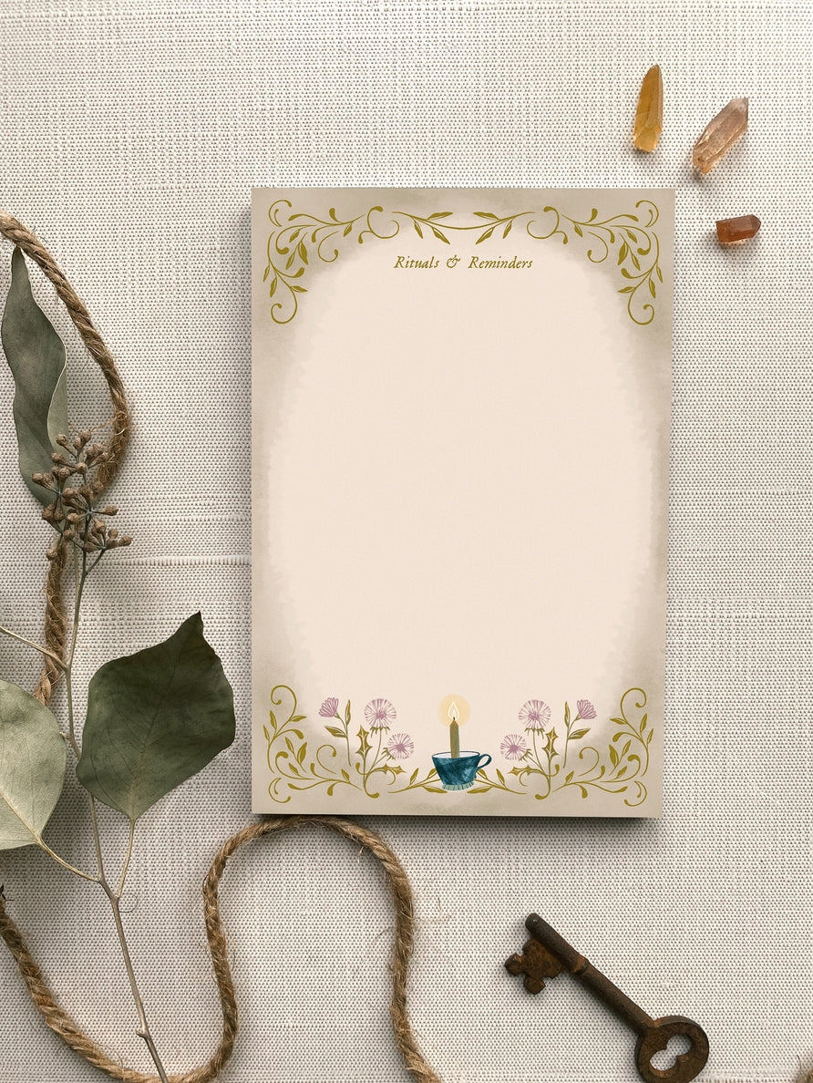 Notepad with "Rituals & Reminders" written at the top with a candle in a teacup surrounded by dandelions at the bottom