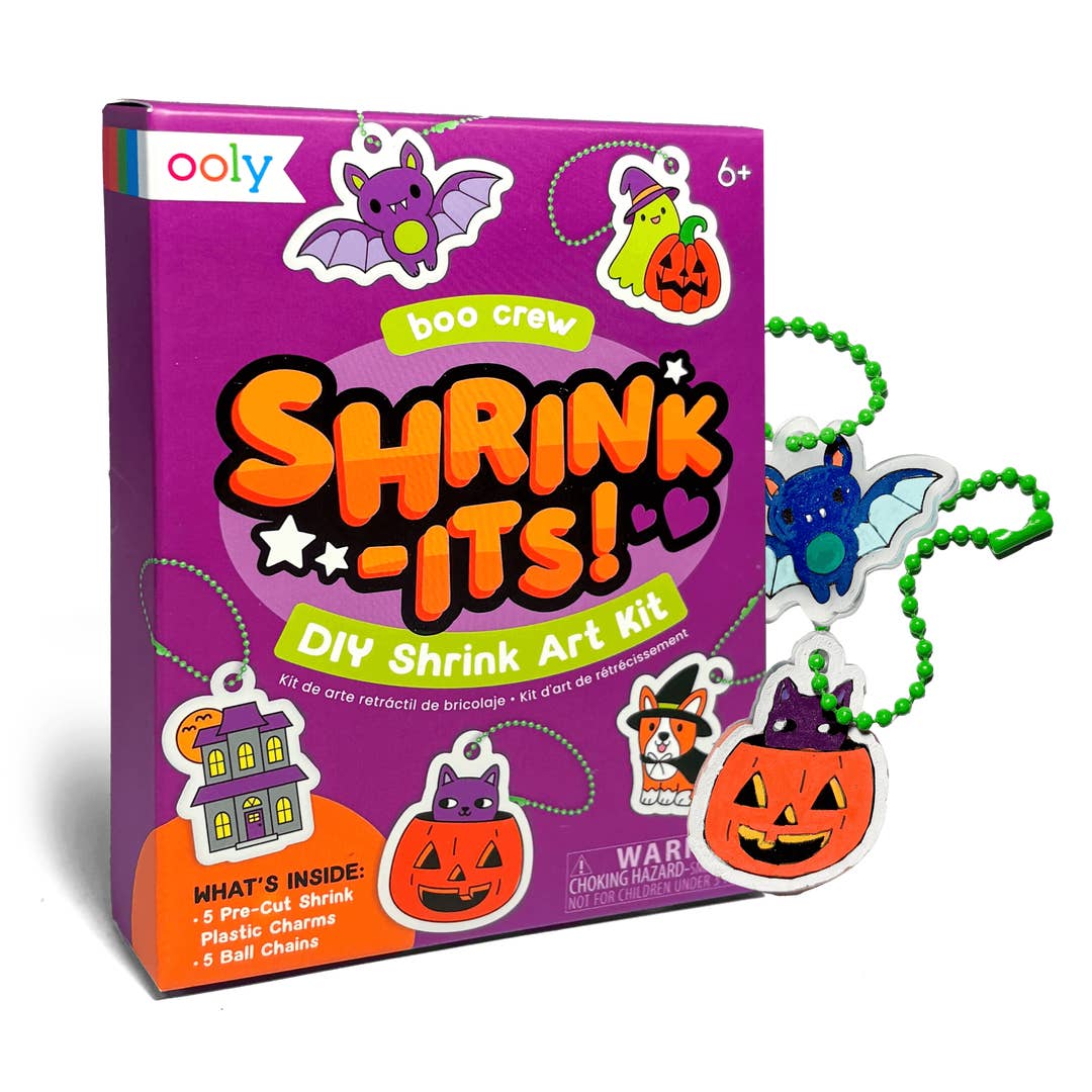 Ooly Boo Crew Shrink-It! DIY Shrink Art Kit box shown with several small Halloween-themed plastic charms attached to green bead chains on a white background.