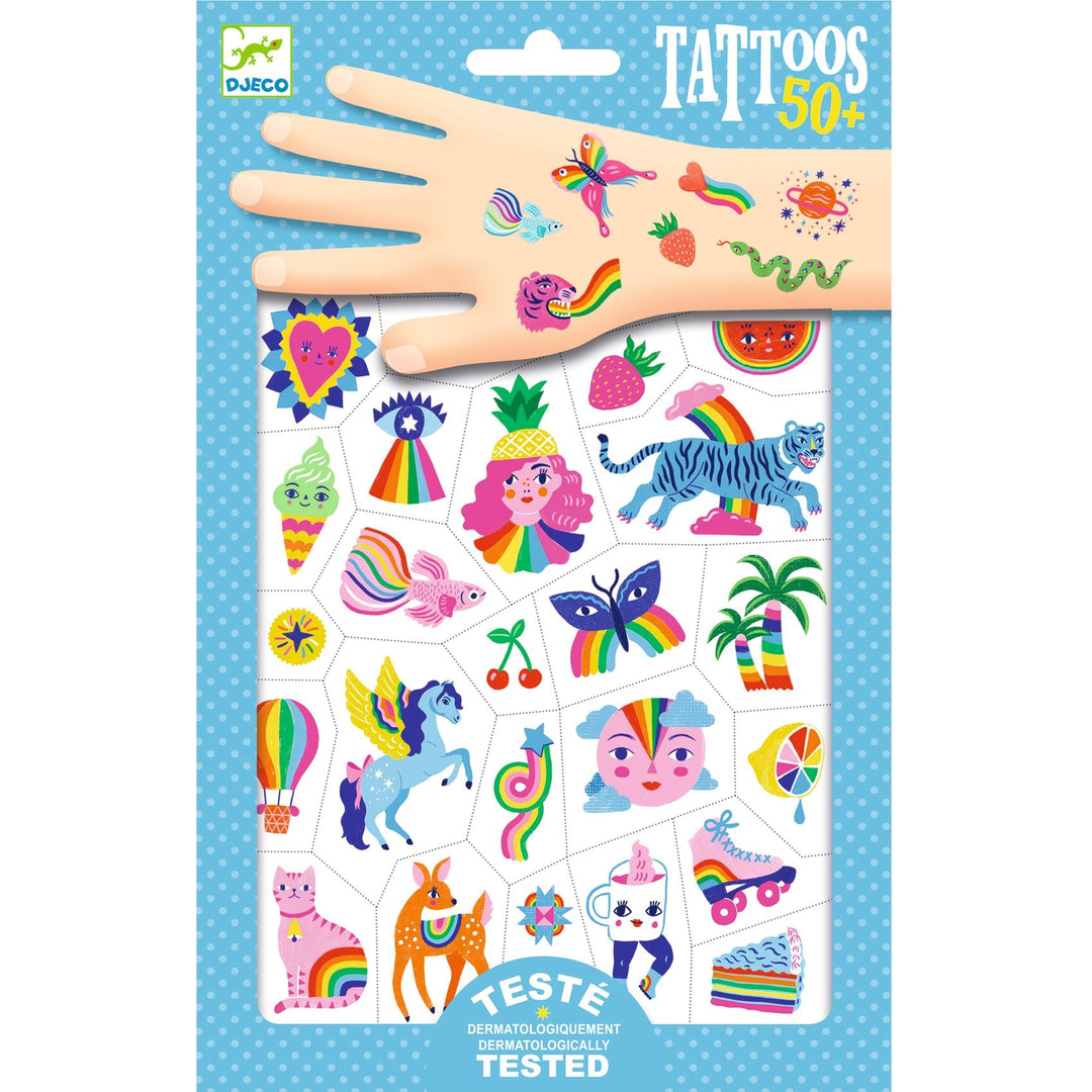 blue package of temporary tattoos showing a variety of rainbow themed tattoos, like rainbow hearts, unicorns, rollerskates and fruit, some are shown on a cartoon hand