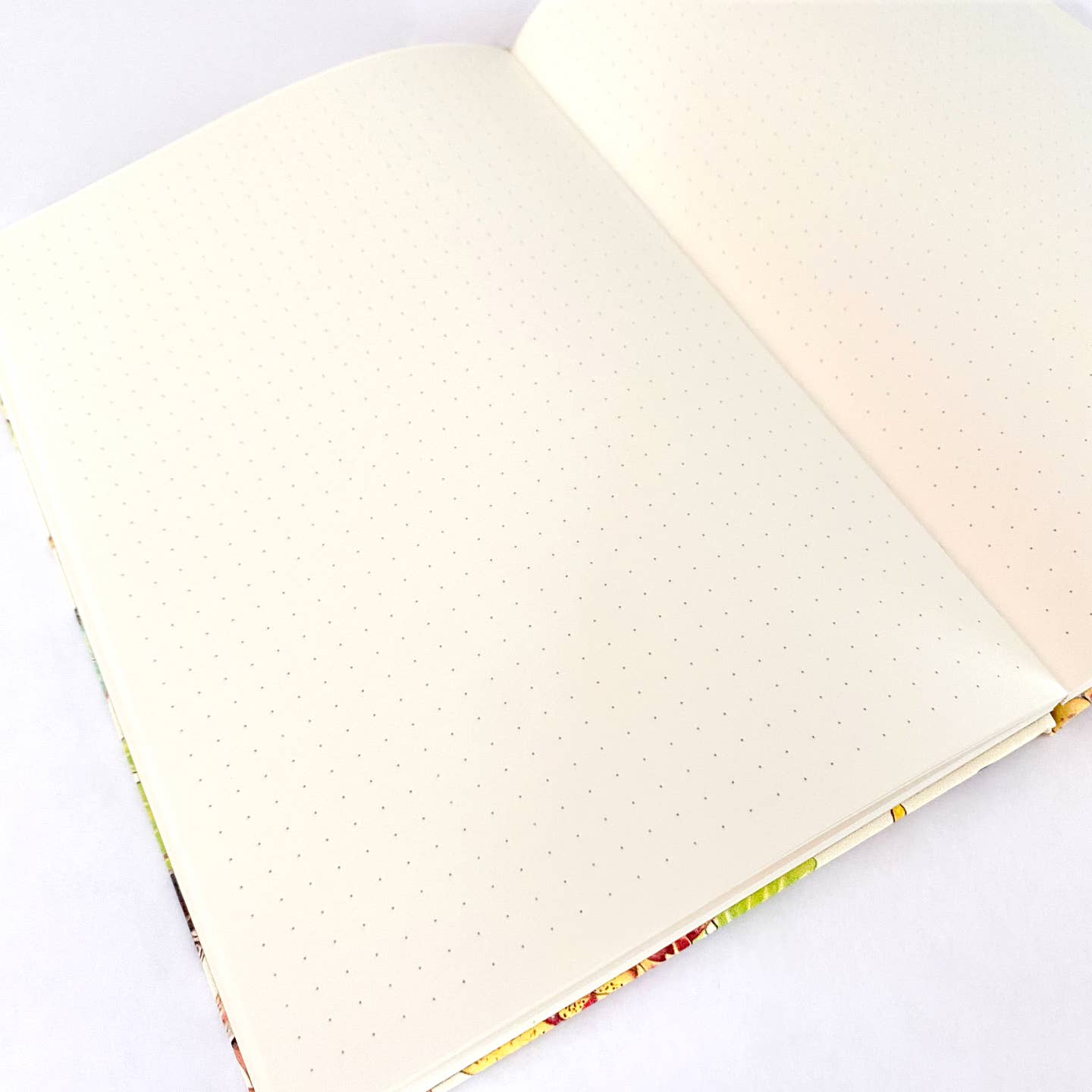 Open notebook with ivory dot grid pages on a white background