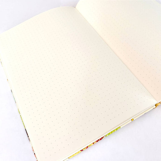 Open notebook with ivory dot grid pages on a white background