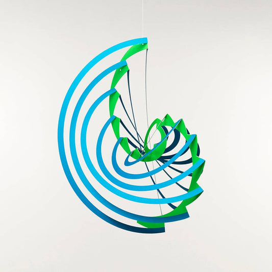 Photo of the completed Voluta 3D Paper Pop Up Mobile in a modern spiral form with blue and green paper on a white background