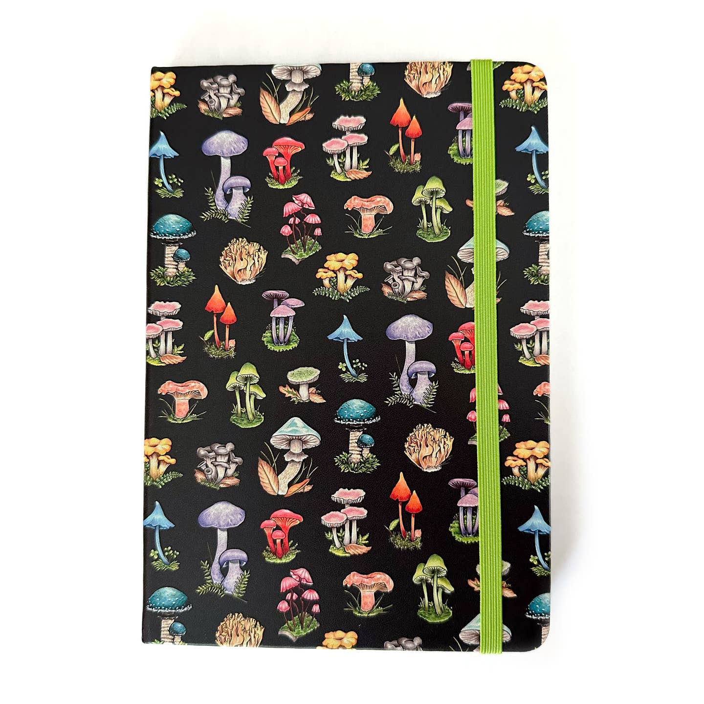 Black notebook with a variety of mushrooms in rainbow colors and a green elastic strap closure on a white  background