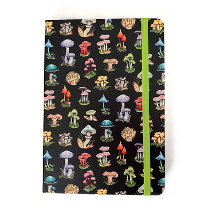 Black notebook with a variety of mushrooms in rainbow colors and a green elastic strap closure on a white  background