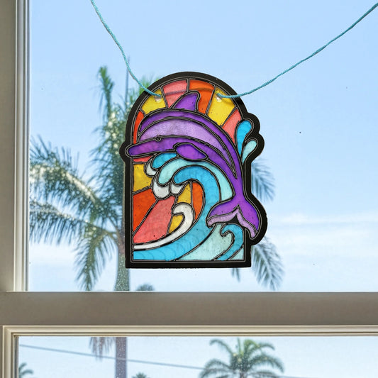A completed banner kit panel featuring a purple dolphin breaching with a blue wave with a suuny sky, shown illuminated in a bright window