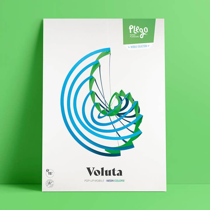 A product box for the Plego Voluta pop-up mobile by Plego, featuring a white background with a blue and green spiral graphic, set against a solid green background.