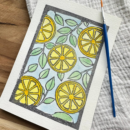 Card with an illustration of many lemon halves with a paintbrush on a wooden background