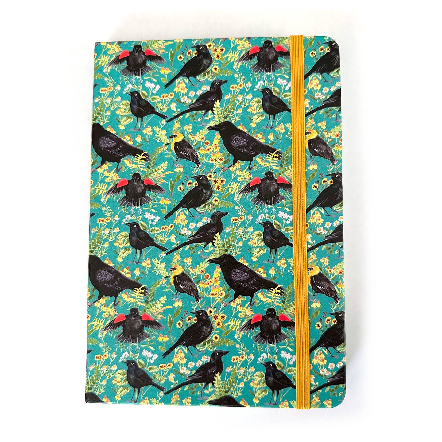 Notebook with blackbirds and crows with a floral pattern on a teal background with a yellow elastic closure strap