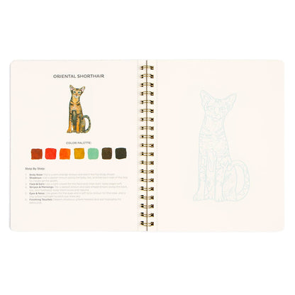 An open spiral-bound notebook showing a cat color guide page titled 'Oriental Shorthair' with a colored cat illustration, color palette swatches, and step-by-step makeup instructions, photographed on a white background.