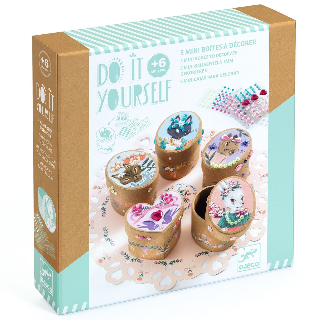 White and mint packaging featuring five small round, oval, and heart shaped boxes decorated with animal portraits, with sparkly gemstone accents