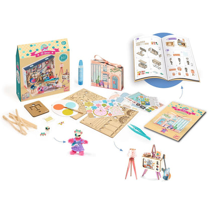 Image shows the kit packaging, instructional booklet, Stella figurine, glue applicator, tweezers, and laser cut wooden panels for model building