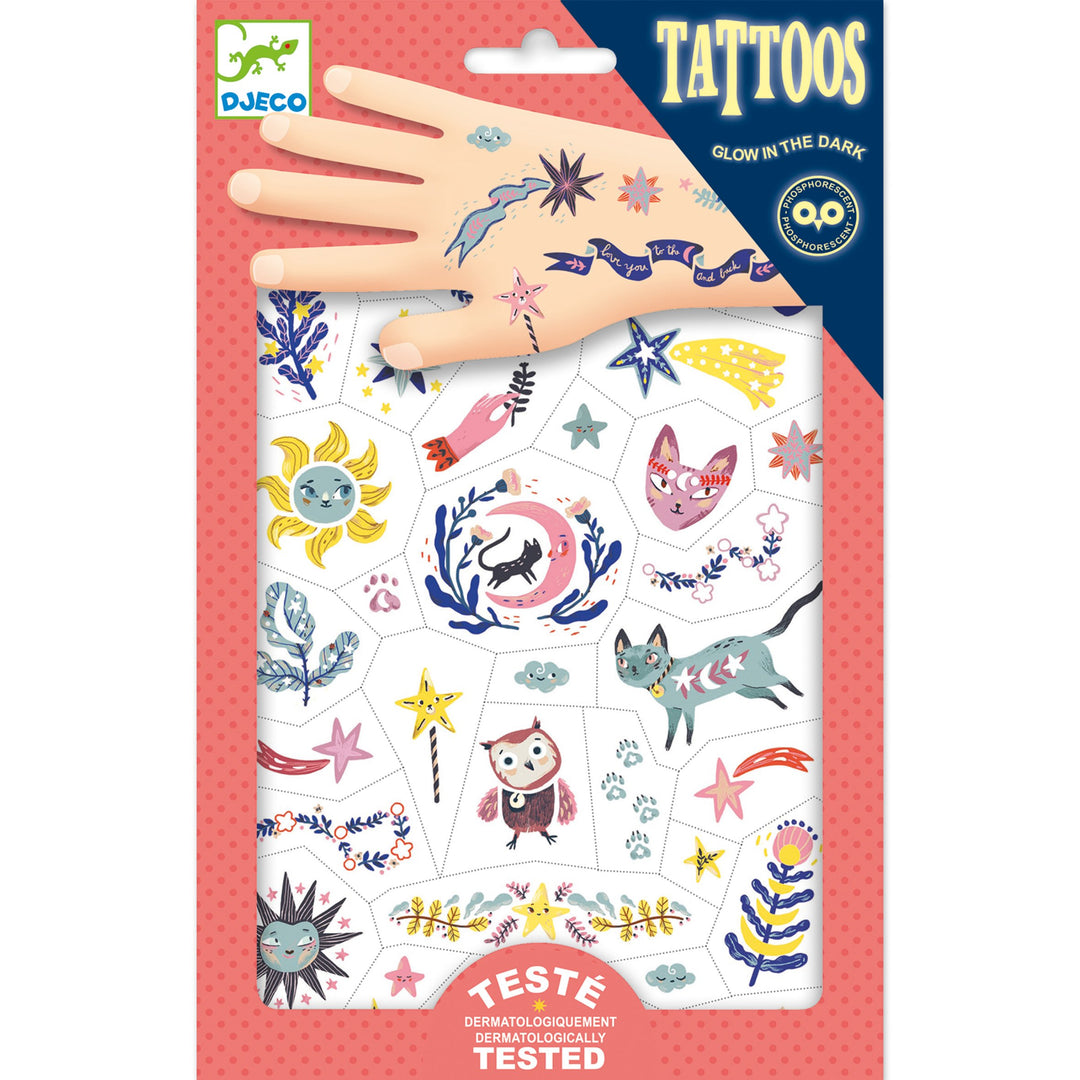 pink package of temporary tattoos showing a variety of night themed tattoos, like cats, owls, stars and moons, some are shown on a cartoon hand