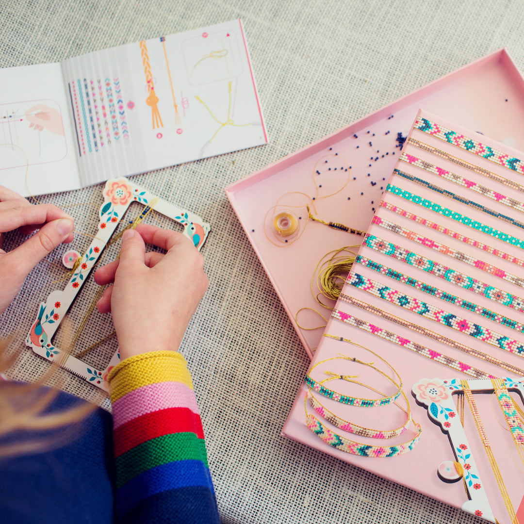 Person making bracelets with a kit on a textured surface