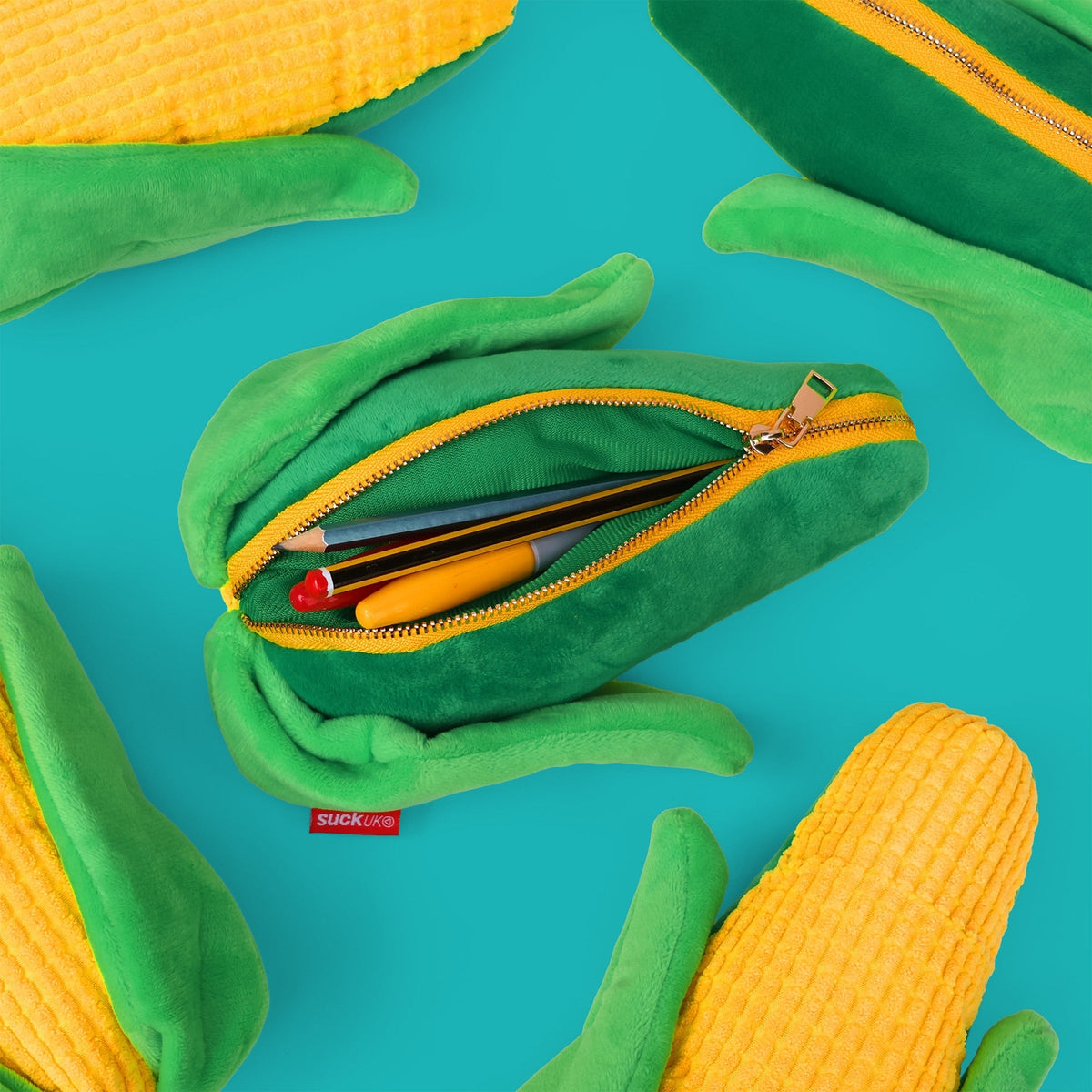 Plush Corn on the Cob pen case shown with open zipper and pens inside