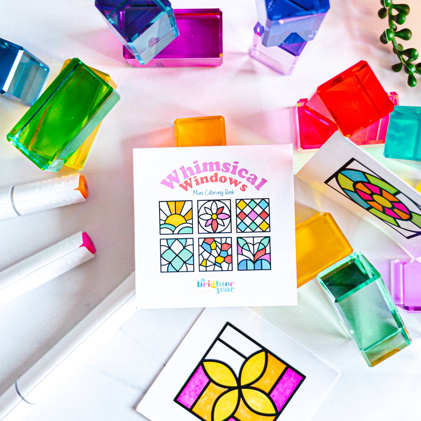the whimsical windows book surrounded by an assortment of rainbow colored acrylic blocks