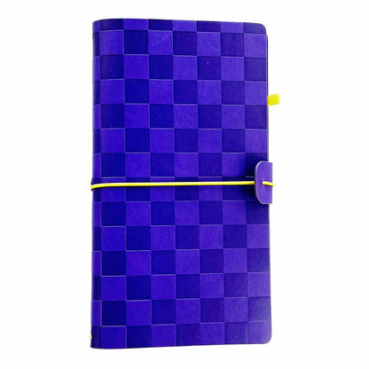 Pipsticks traveler notebook cover with a blue checkerboard pattern cover, secured by a yellow elastic band and featuring a purple tab closure.