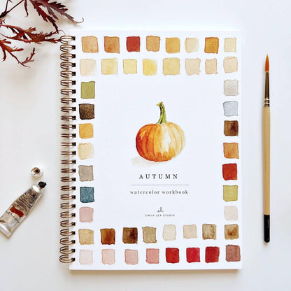 Watercolor workbook with autumn theme featuring a pumpkin illustration on a white background.
