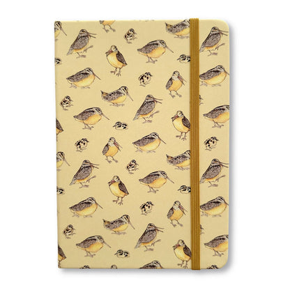 a beige notebook with a pattern of adult and juvenile woodcocks and a gold elastic strap closure on a white background